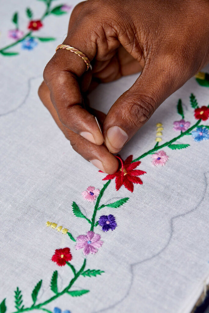 Live hand embroidery personalising fabric and paper products during a corporate brand activation event.
